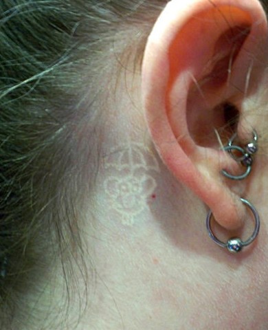 white tattoo behind ear